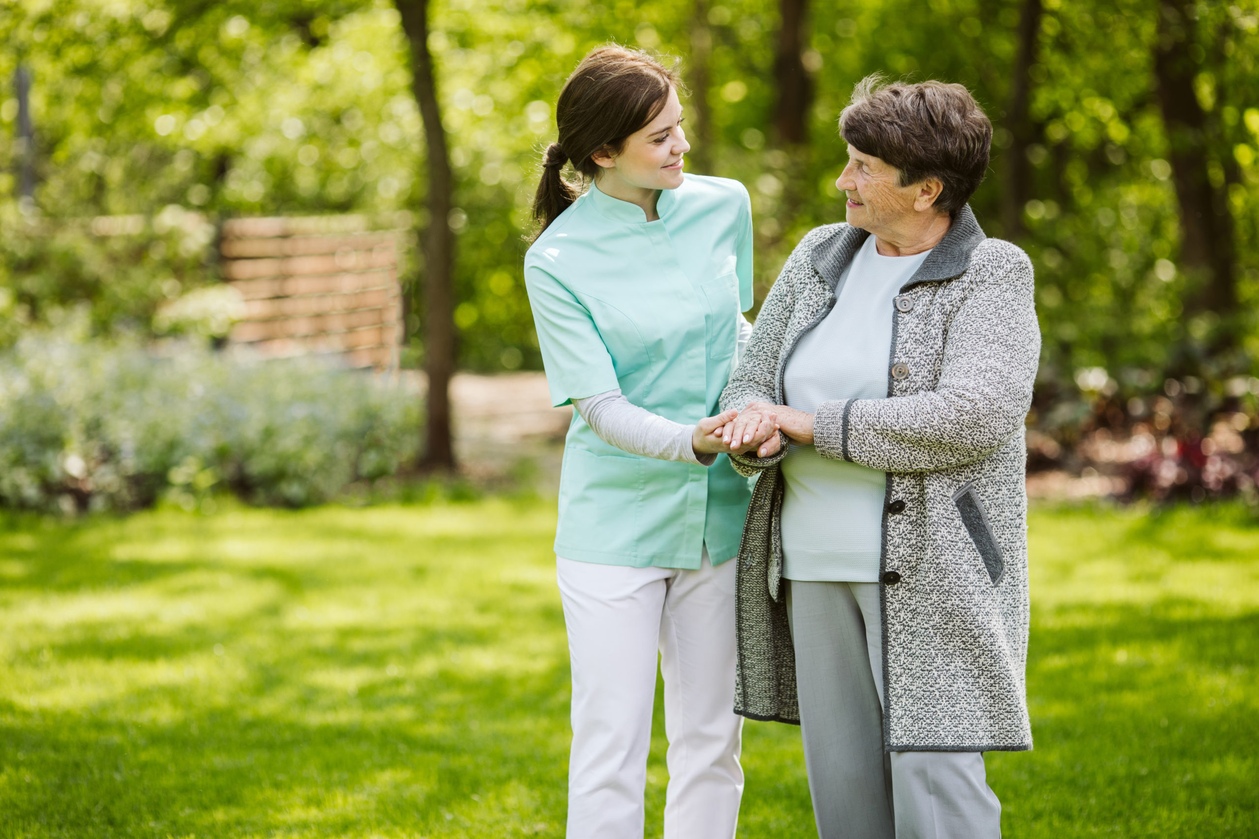 Nurse and patient in the garden of modern senior home with daily care